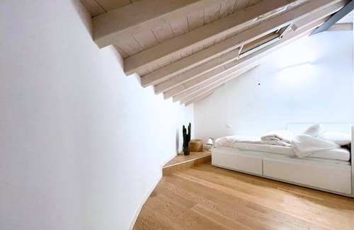 Bassano del Grappa Apartment | Casa Tonde, a modern attic with exposed beams.