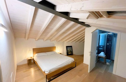 Bassano del Grappa Apartment | Casa Tonde, a modern attic with exposed beams.