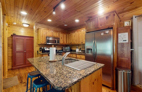 Cherry Log Cabin | Creek Cabin with fenced yard, screened in patio and hot tub