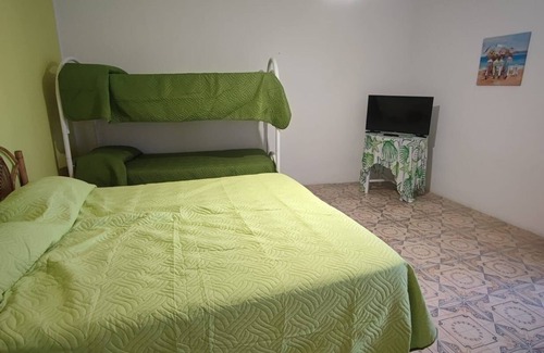 Stromboli Villa | Green room with 4 beds, bathroom and patio with equipped kitchen