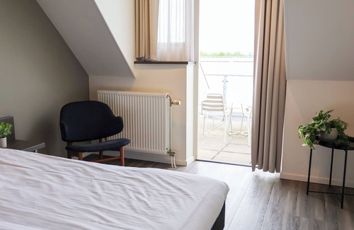 Municipality of West Maas en Waal Hotel | Luxury room with a balcony overlooking De Gouden Ham, offering modern amenities and a serene, picturesque setting.