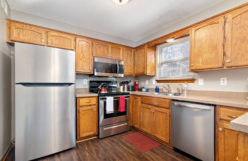 Raymore House | Spacious Oak Haven: 3 King Beds, Hot Tub & Free Parking
