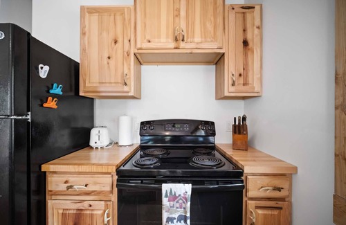 Carp Lake Cabin | Lakefront Log Cabin with Pool & Family-Friendly Amenities