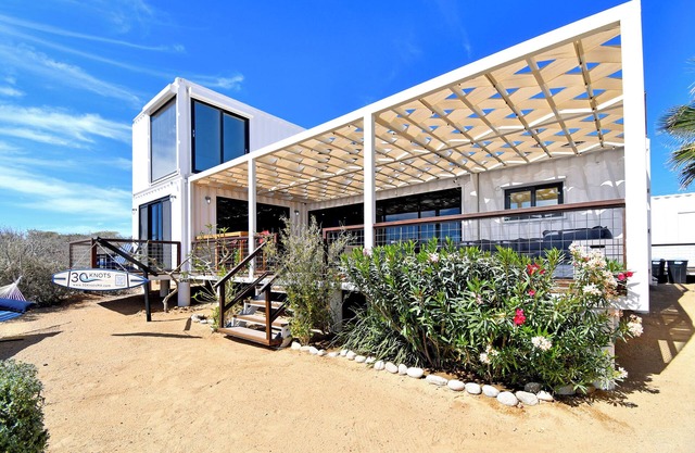 3 bedroom, 3 bath premium repurposed shipping container home with a Bullfrog X8 premium hot tub. Daily housekeeping (except Sundays) available for no additional fee. Free use of inflatable SUPs, beach chairs, a large sun shade & other beach toys.