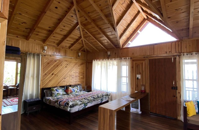 A wooden cottage in an fruits orchard facing Himalayas n