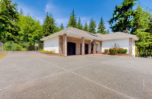 Custom, dog-friendly home on 5 lakefront acres with tennis, sauna & game room