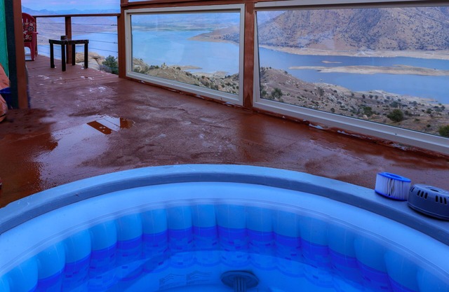 High on a mountainside with a hot tub on a deck.