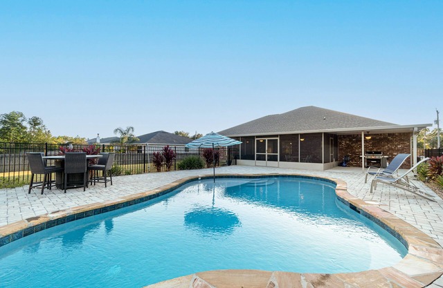 Single-level home with pool, enclosed yard, screened lanai, grill & home office