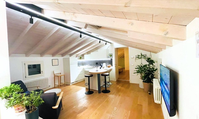 Bassano del Grappa Apartment | Casa Tonde, a modern attic with exposed beams.