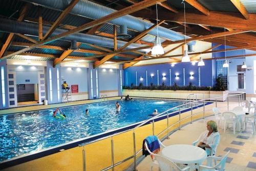 New Forest District Cabin | Relax at Crescent 6: Poolside Paradise with Ocean Views
